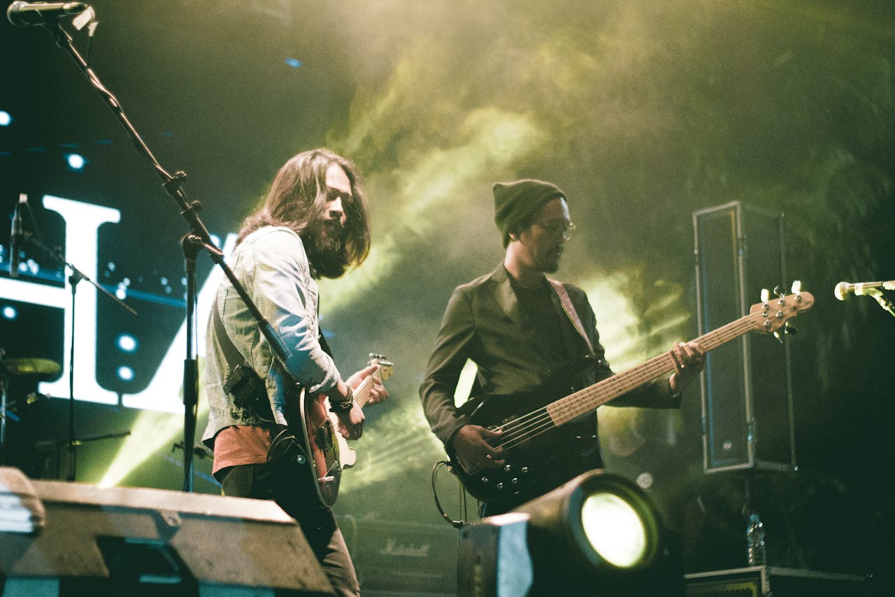 Energetic musicians playing guitars during a live concert at night.